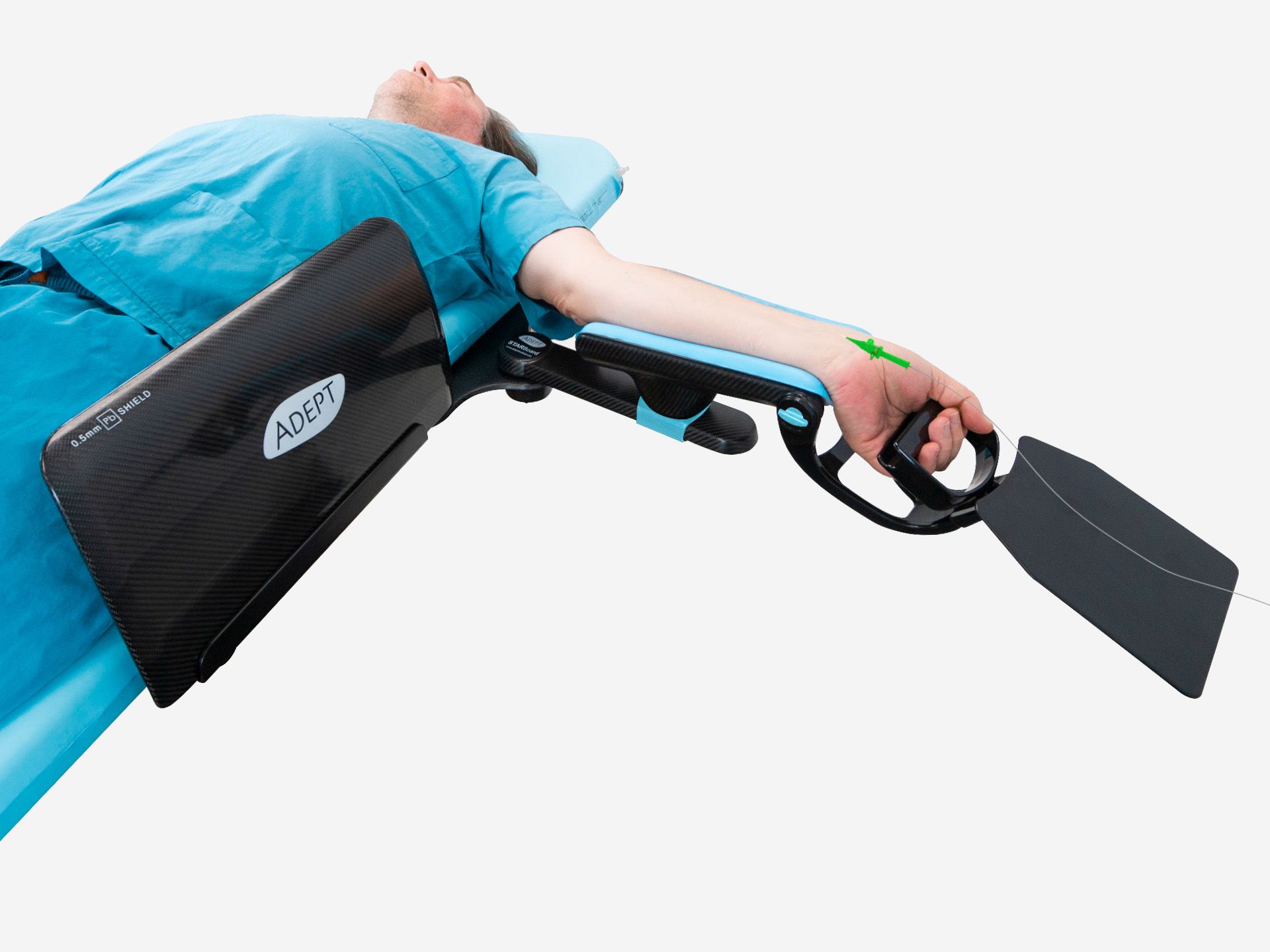 Patient in blue gown on a medical table with their left arm secured in a black and blue ADEPT arm support device, holding a handle. A green arrow is drawn on their wrist.