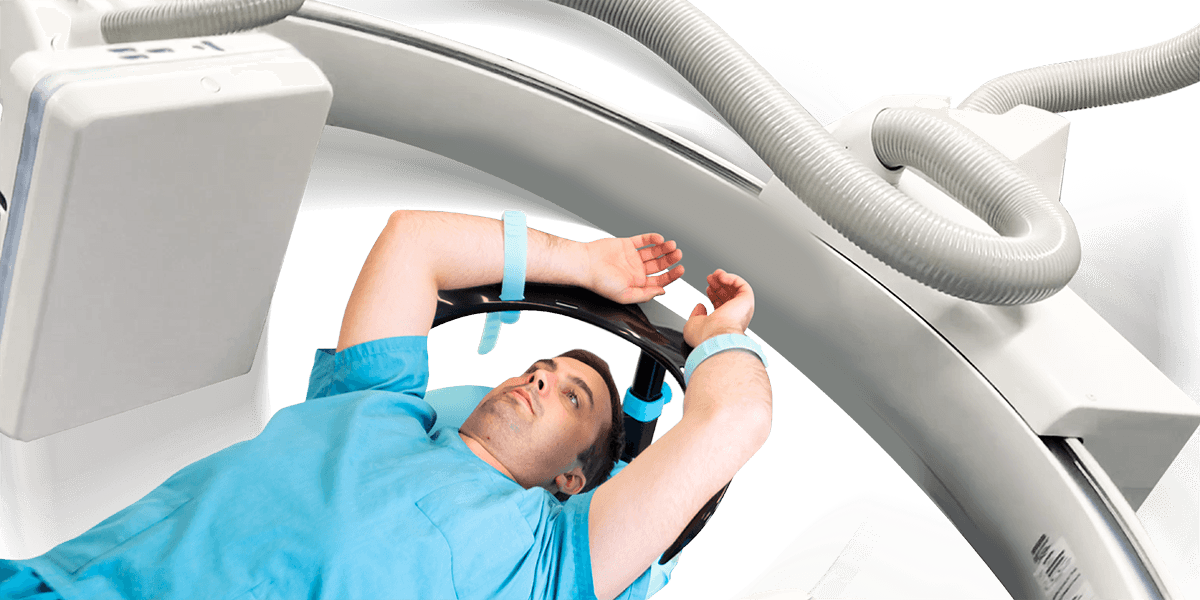 Adult male patient positioned with both arms overhead using the Adept Medical Overhead Arm Support MR Safe during imaging. Device fits through CT and MRI bores 700 mm or larger.